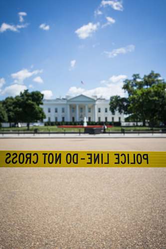 washington Police line-do not cross stanchion near trees under blue sky at daytime the white house